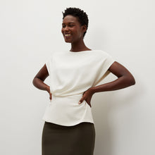 Front image of a woman standing wearing the Nejvi Top in alabaster