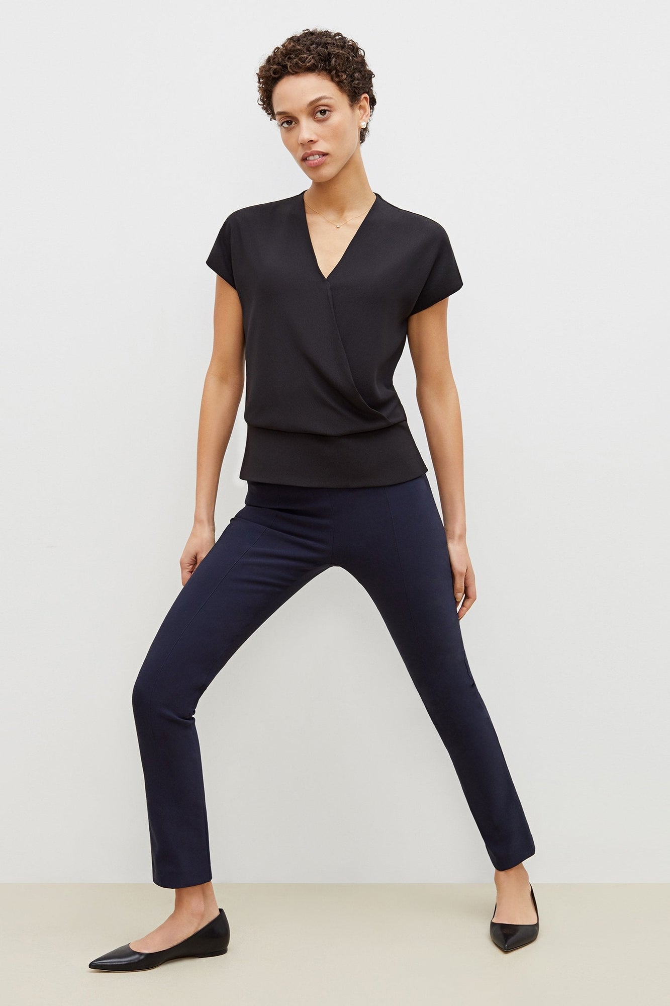 Front image of a woman standing wearing the foster pant in dark navy | Grid | Exclude