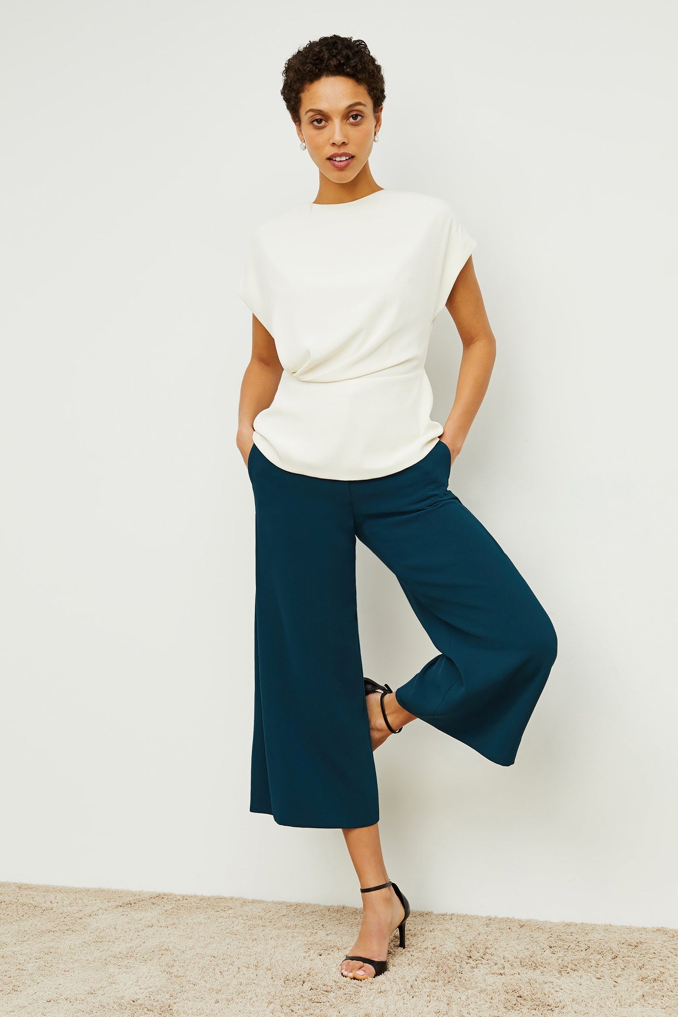Front image of a woman standing wearing the Nejvi Top in alabaster | Exclude