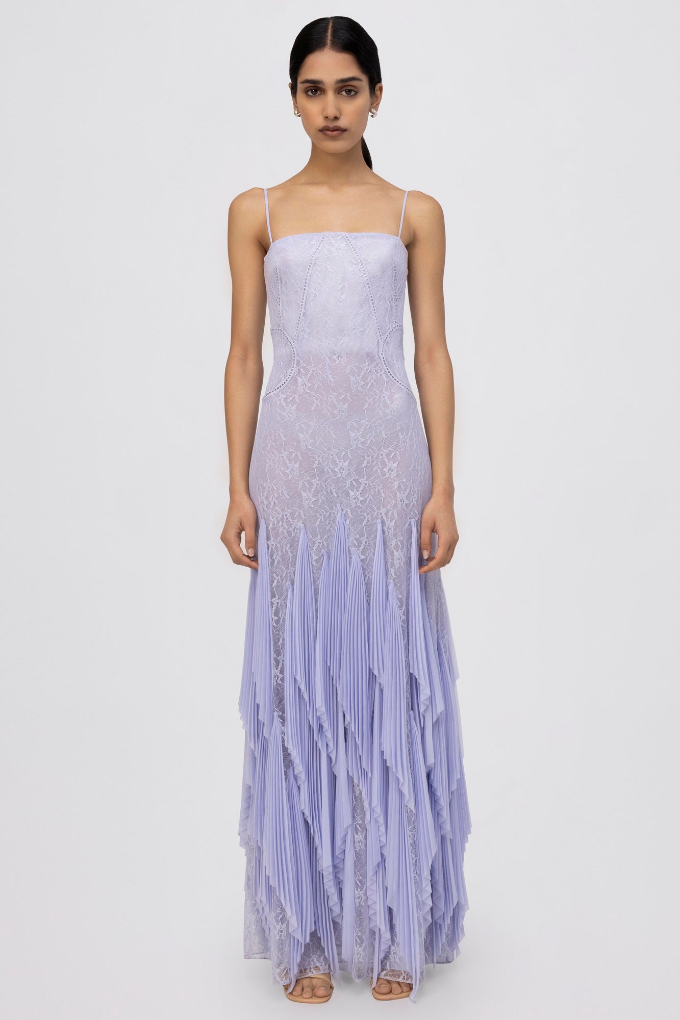 Lavender lace gown with thin straps, fitted bodice, and pleated skirt with layered hem.