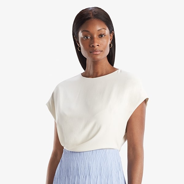 Grid image of a woman standing wearing the Nejvi Top in alabaster | Exclude