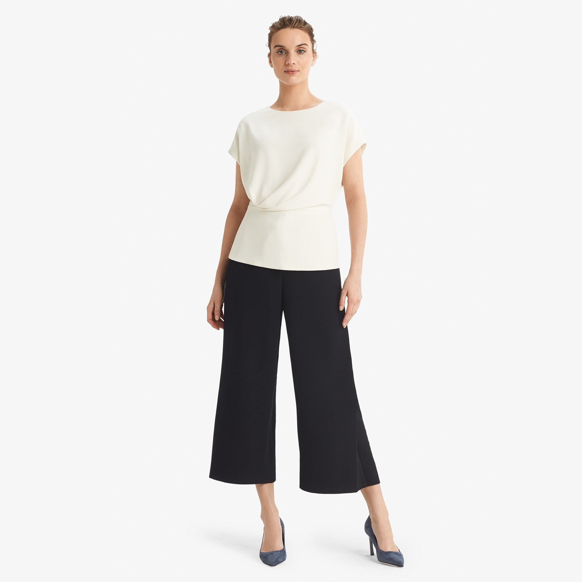 Hero image of a woman standing wearing the Nejvi Top in alabaster | Exclude