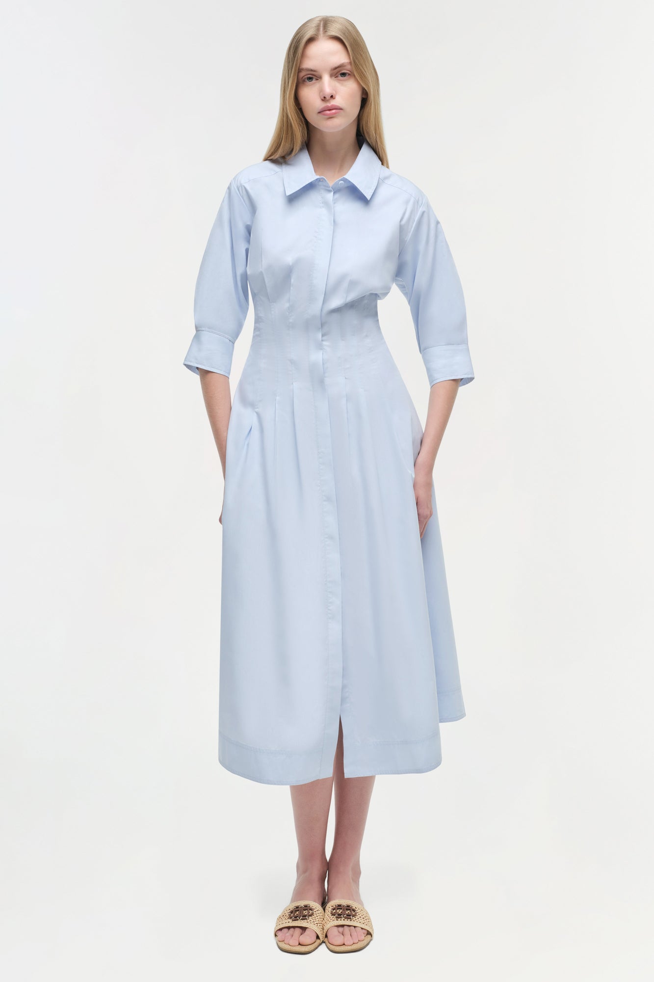 Light blue button-front midi dress with three-quarter sleeves, collared neckline, and pleated skirt on model.