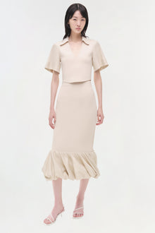 Cream linen knit midi skirt with gathered bubble hem, worn with matching short-sleeve crop top.