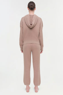 Beige cable knit hoodie and matching jogger pants on model, shown from back view.