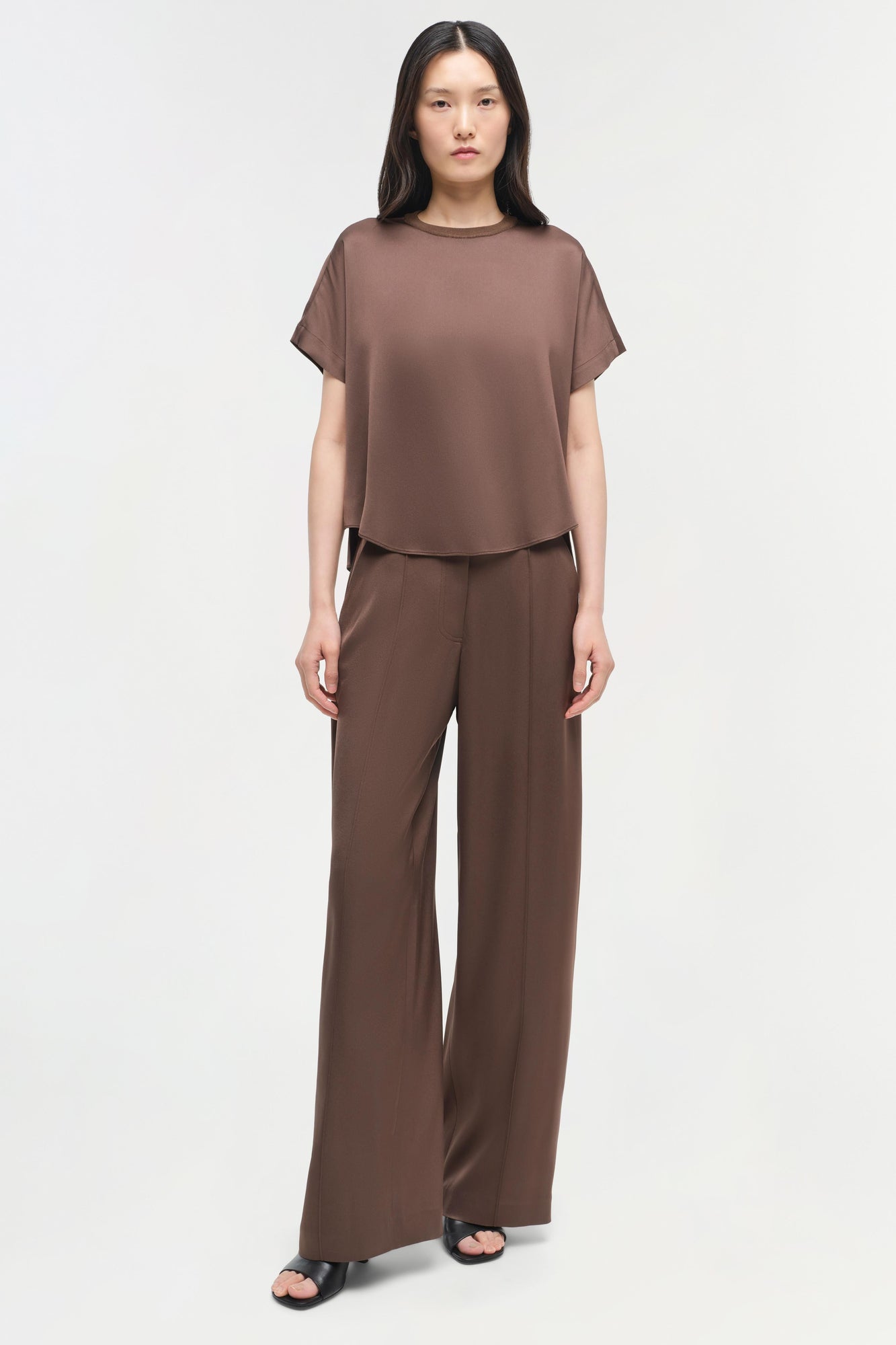 Brown satin t-shirt with short sleeves and crew neckline worn with matching wide-leg satin pants.