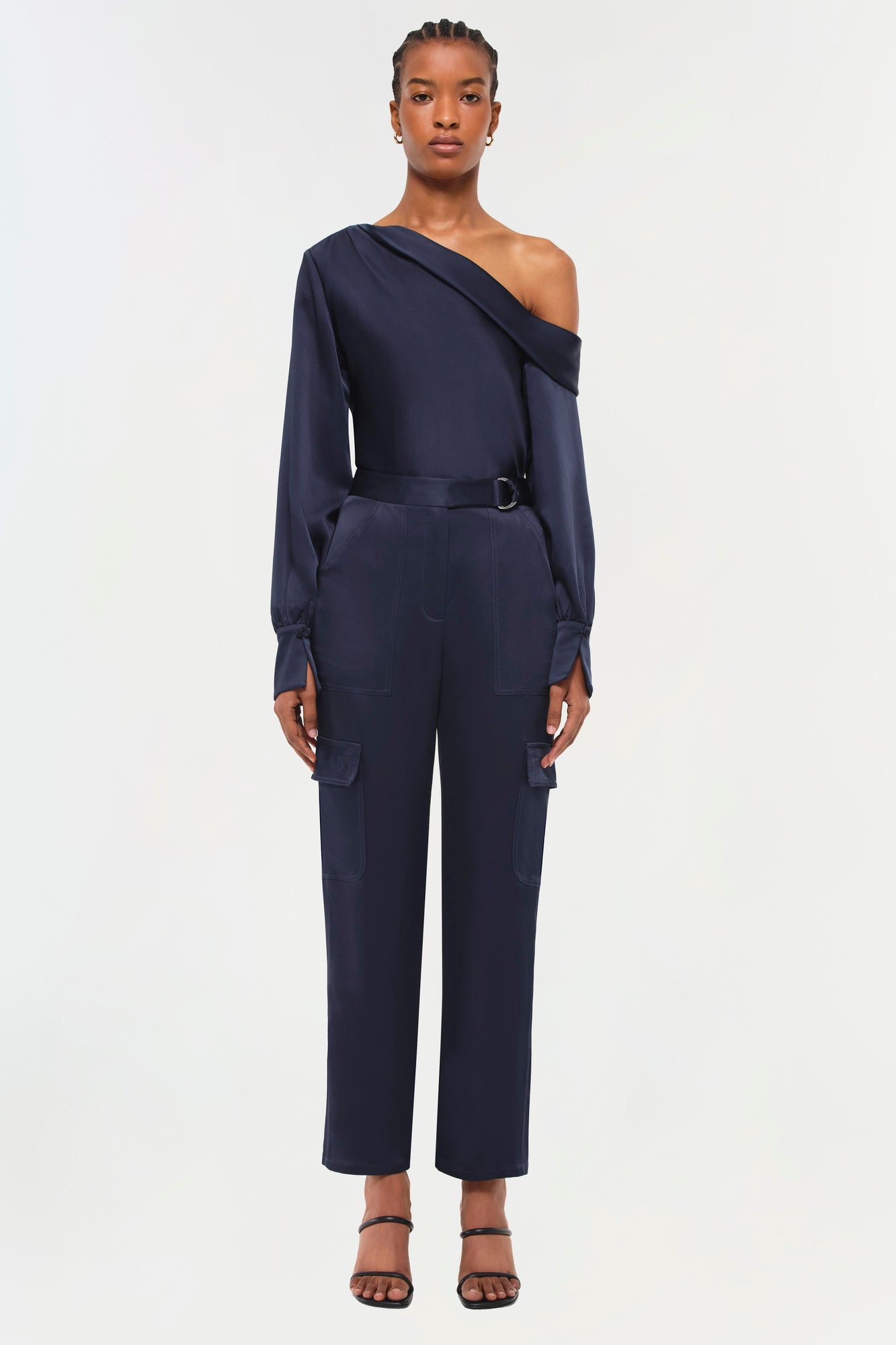 Navy cargo pants with side pockets and belt detail, shown on model wearing off-shoulder long-sleeve top.