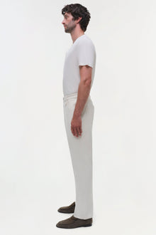 Man wearing white wide-leg jeans with a white t-shirt, shown in side profile.