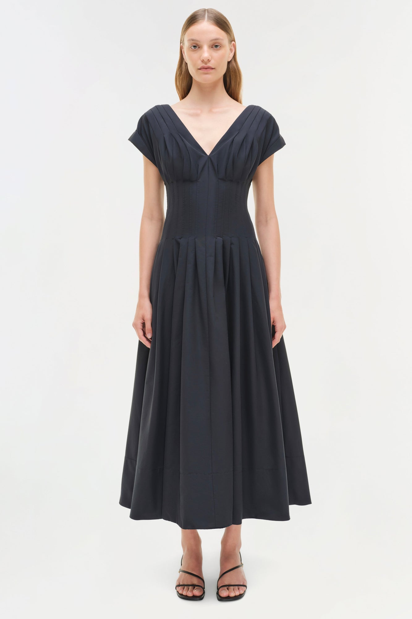 Dark navy cotton midi dress with V-neckline, short sleeves, pleated bodice, and full A-line skirt.