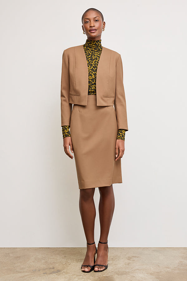 Front image of a woman standing wearing the Neale jacket in camel | Exclude