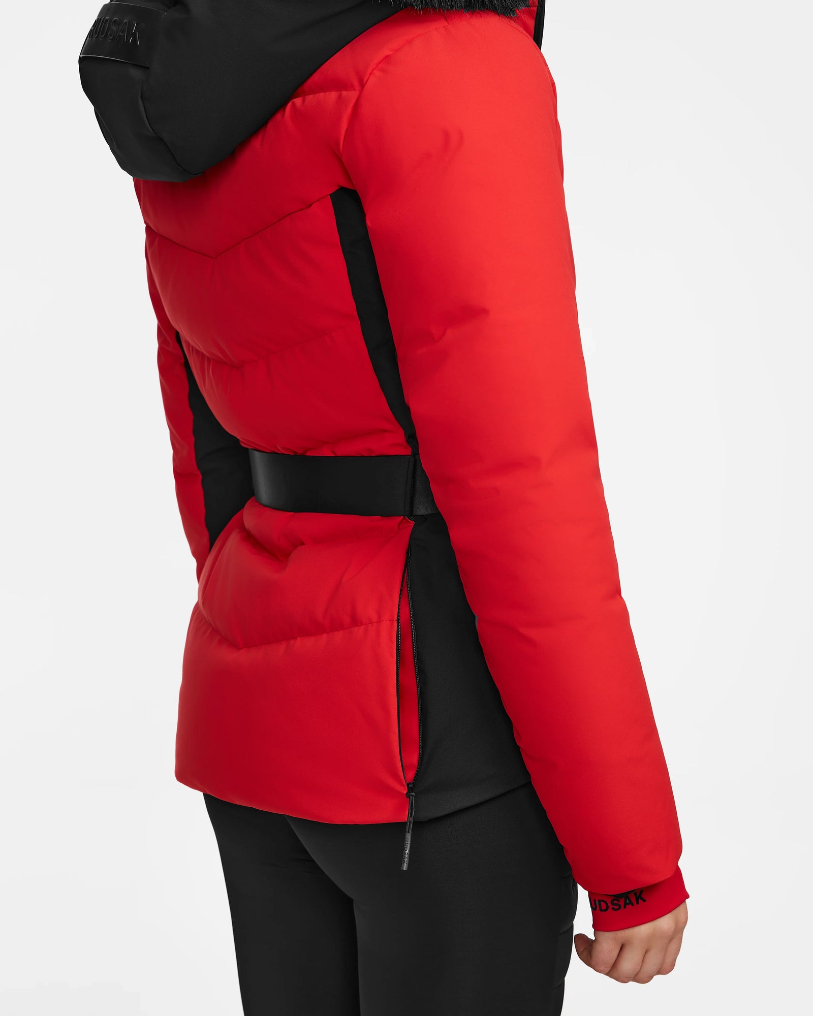A person in the Rudsak ALAIA - 8124816 Flame Red ski jacket with a hood, shown from the back and side, styled with black pants against a plain white background.