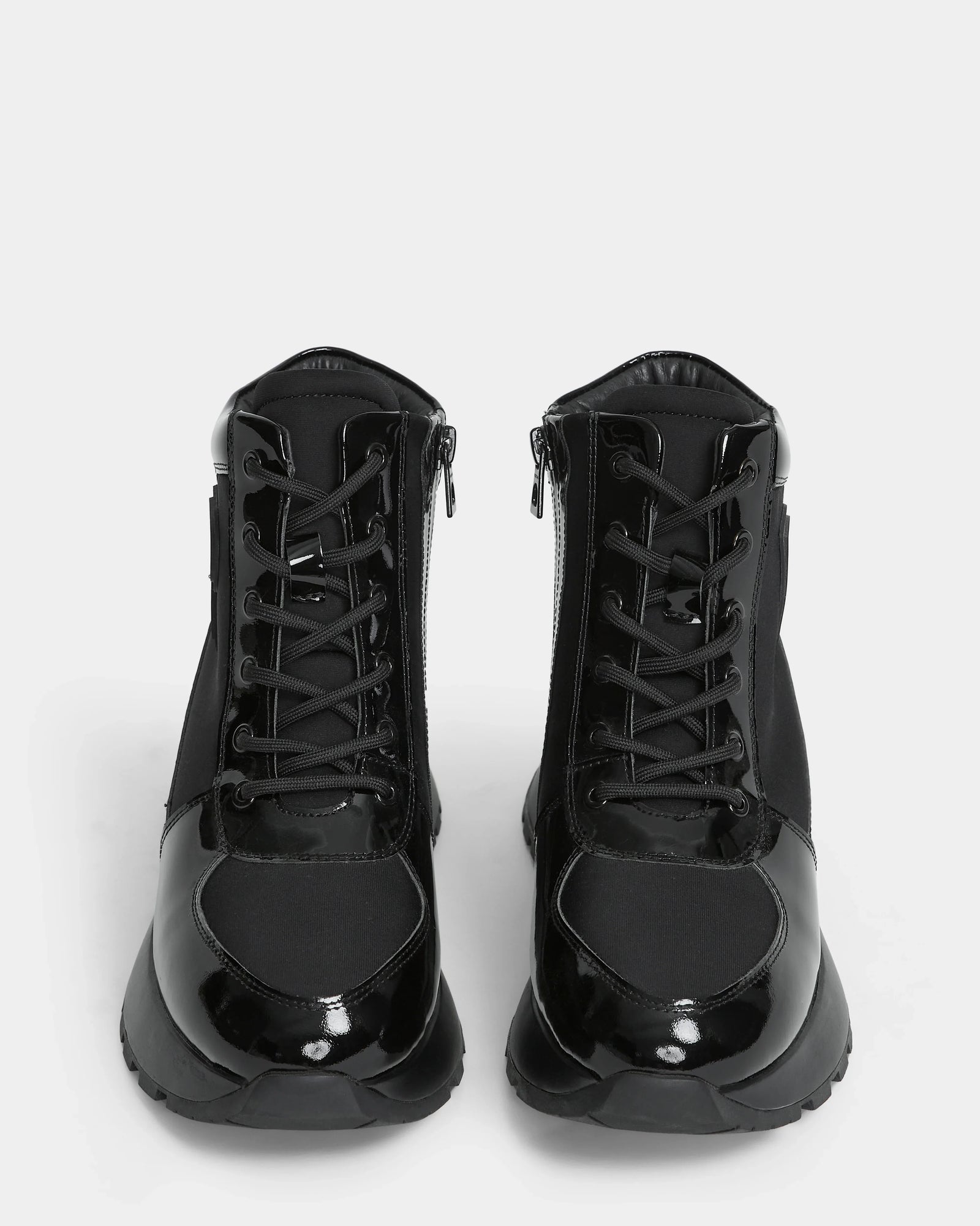 The Rudsak CHELSA - L224505 Black women’s sneaker boots feature glossy patent leather accents, lace-up fronts, and waterproof zipper sides, shown facing forward against a white background.