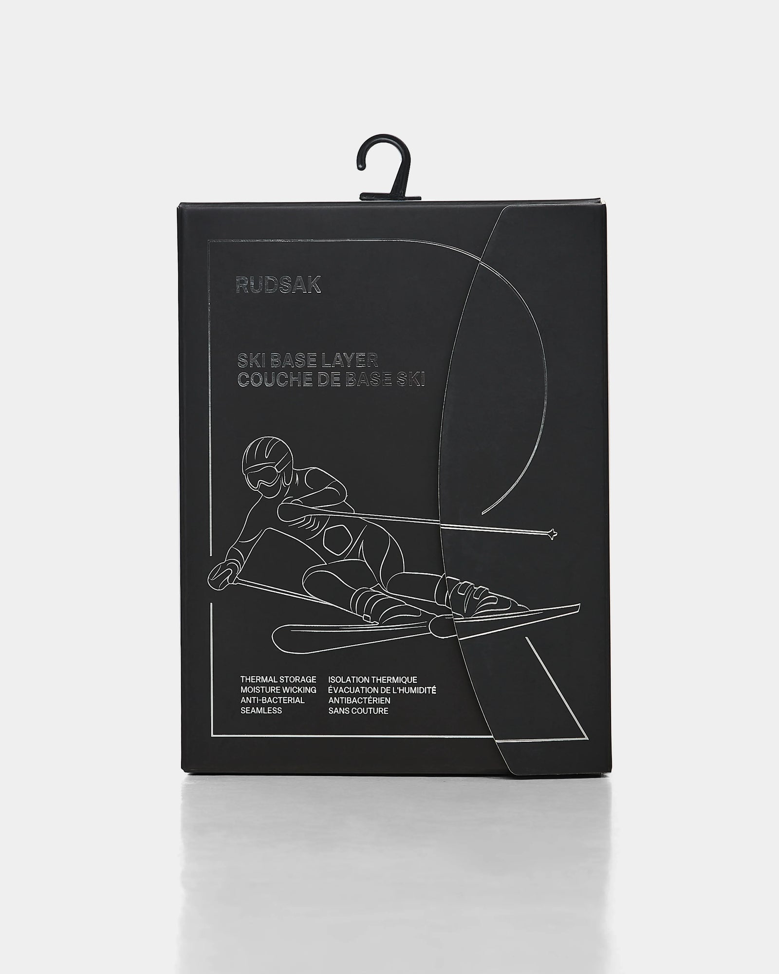 Black rectangular box with minimalist white line art of a skier in motion. The packaging, labeled Rudsak FRANC - 6524541 Black men’s thermal set, displays English and French text and has a black plastic hanger at the top.
