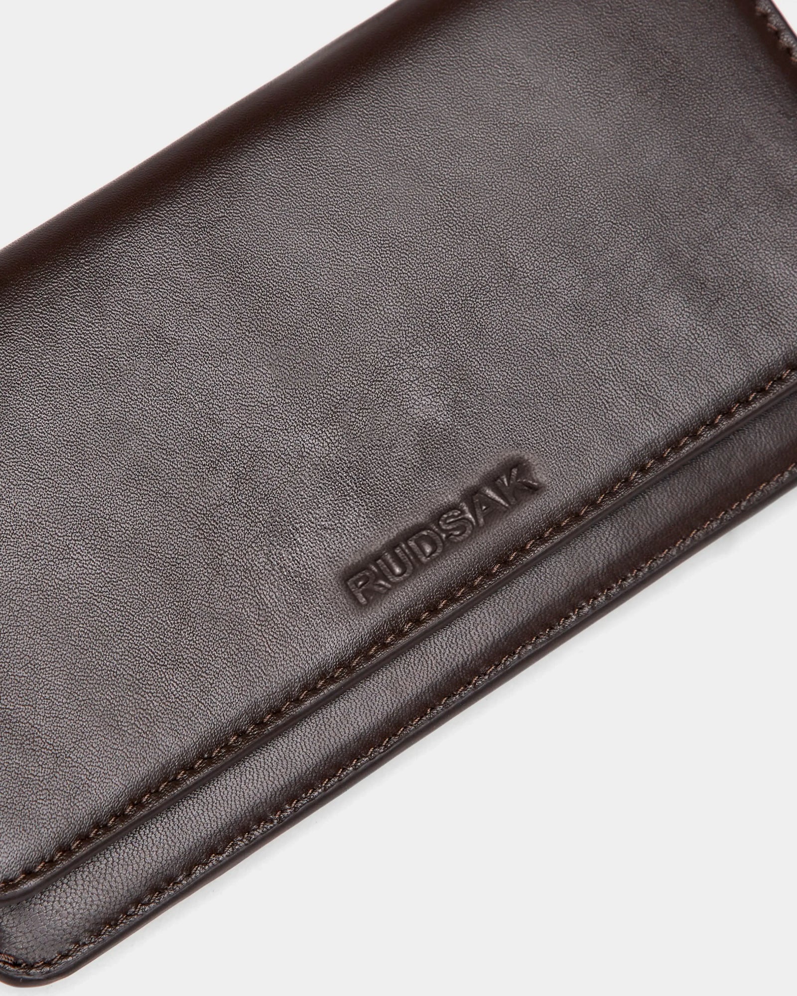 A close-up of the PREYA - 8324508 Espresso wallet by Rudsak, featuring dark brown leather, the Rudsak logo embossed on the surface, and fine stitching along the edges.