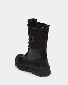 The Rudsak RITA - L222502 Black is a women’s black high-top winter boot with weather-treated leather, thick rubber sole, visible laces, and embossed branding on the side and back heel, displayed on a plain white background.