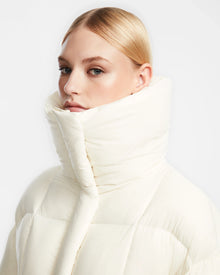 A woman in the Rudsak SASH - 8124536 Iceland womens down puffer coat stands with confidence, ready to conquer winters chill.