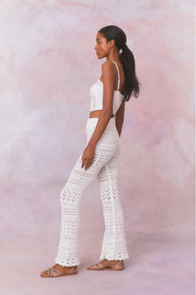 White cotton pointelle crochet floral flare pants with a self tie detail at center front on the double ribbed waistband.