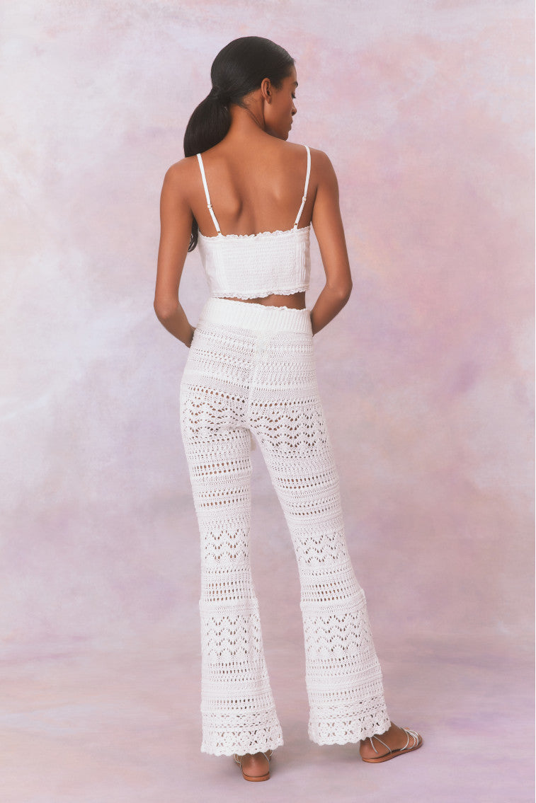 White cotton pointelle crochet floral flare pants with a self tie detail at center front on the double ribbed waistband.