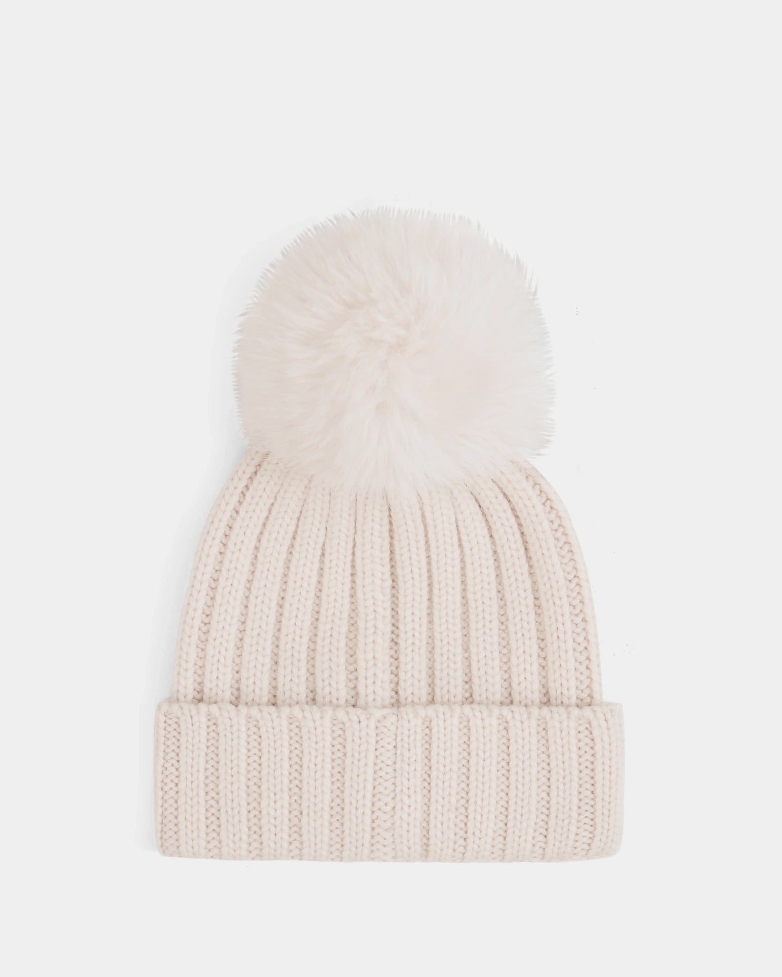 The Rudsak ANISA - L423500 Vanilla is a cream-colored, ribbed knit beanie with a large faux fur pom pom—an essential winter accessory—shown on a plain white background.