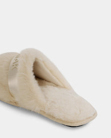 A close-up of the FLUFF - L223509 Cream women’s faux-fur slipper by Rudsak, featuring plush material, a satin band detail, and non-slip traction for cozy downtime—all shown on a white background.