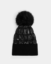 The Rudsak LANYA - L423514 Metallic Black is a women's shiny black quilted pom pom hat, featuring a large fluffy top and ribbed knit cuff, made from a cozy wool blend and shown on a plain light gray background.