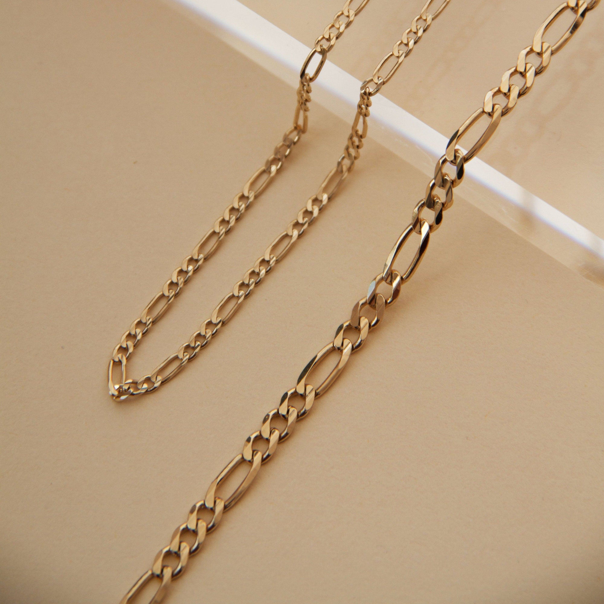 Flatlay Model. Close up of gold chain bracelets on neutral background