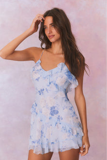 Blue chiffon mini dress with thin spaghetti straps and asymmetrical ruffles that descend from the neckline through the skirt.