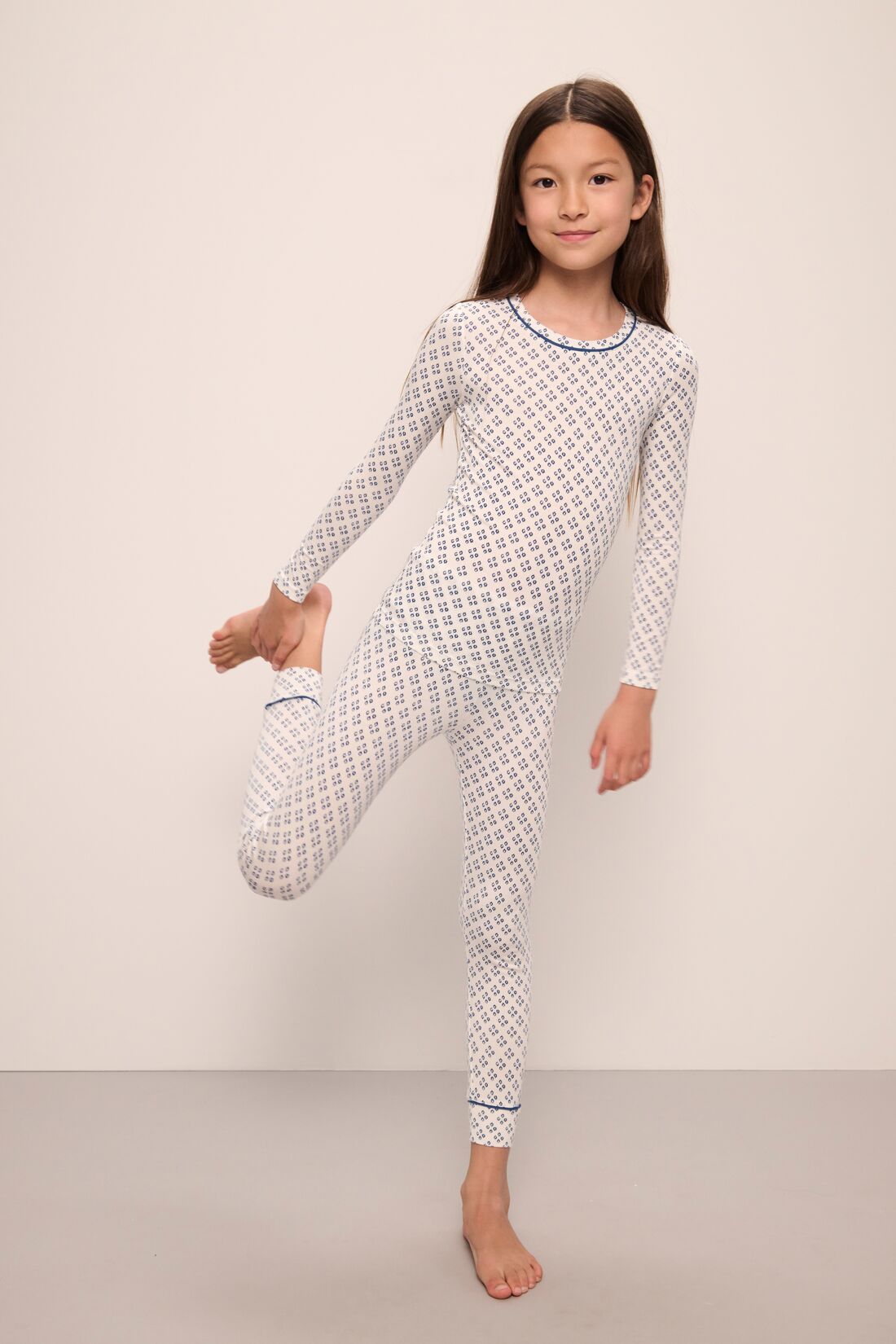 Model wears Kids Printed TENCEL Modal Unisex Long PJ Set in Petite Batik Ivory/Denim Blue.