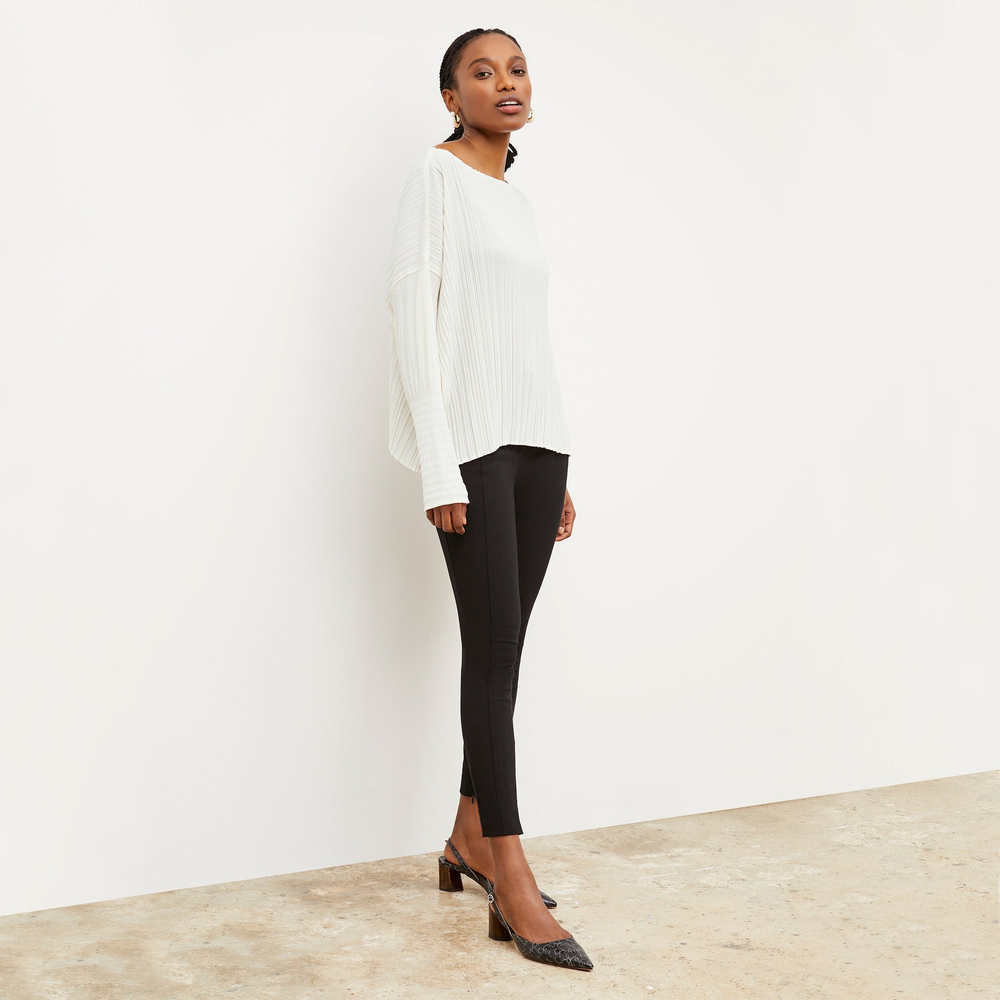 Front image of a woman standing wearing the curie pant in black | Exclude