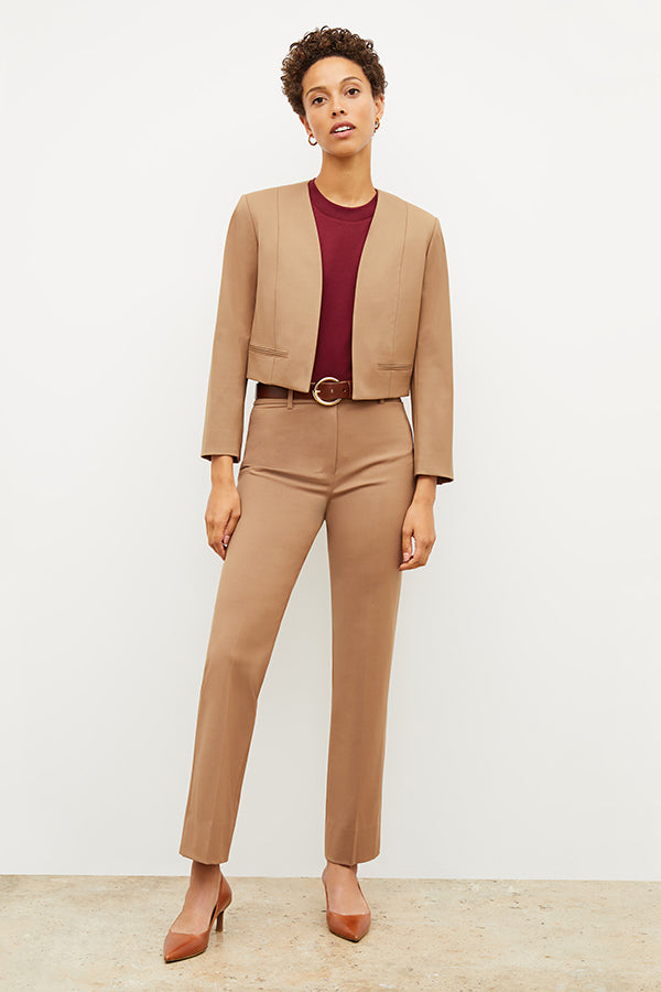Front image of a woman standing wearing the Neale jacket in camel | Exclude 