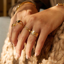 Lifestyle Model Close-up of a woman's hand resting on a textured sweater, wearing multiple gold rings