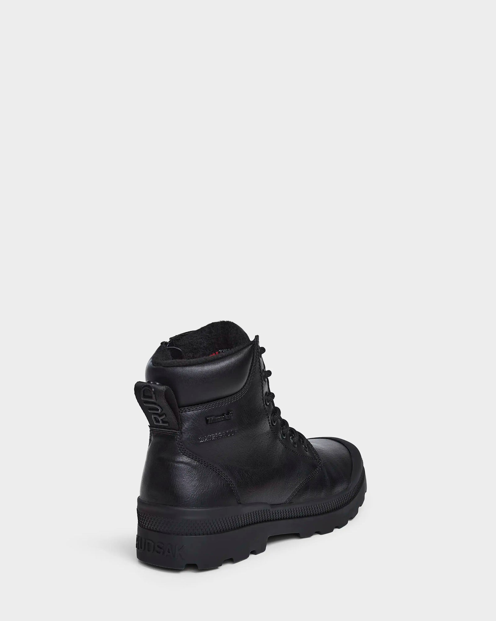 The Rudsak ARTUR - M223501 Black men's ankle boot, crafted from weather-treated leather, is shown angled on a white background, featuring a rugged sole and embossed branding for stylish durability.