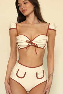 Oat and terracotta bikini bottom with contrasting binding trim and curved pocket details.