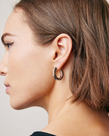 Model wearing huggie earring. 