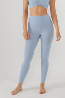 Pale blue ribbed leggings with high waist and cropped top on model against white background.