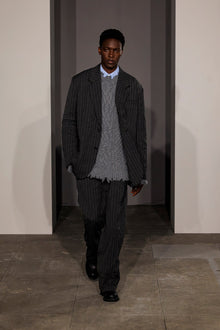 Charcoal pinstriped double pleat pants worn with matching blazer and gray sweater.