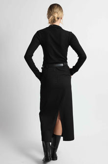 Woman wearing a black outfit on a light grey background