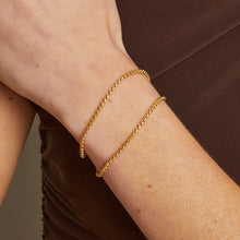 Model. Gold bracelet on a wrist with a neutral background
